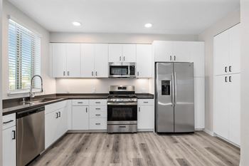a kitchen with white cabinets and stainless steel appliances